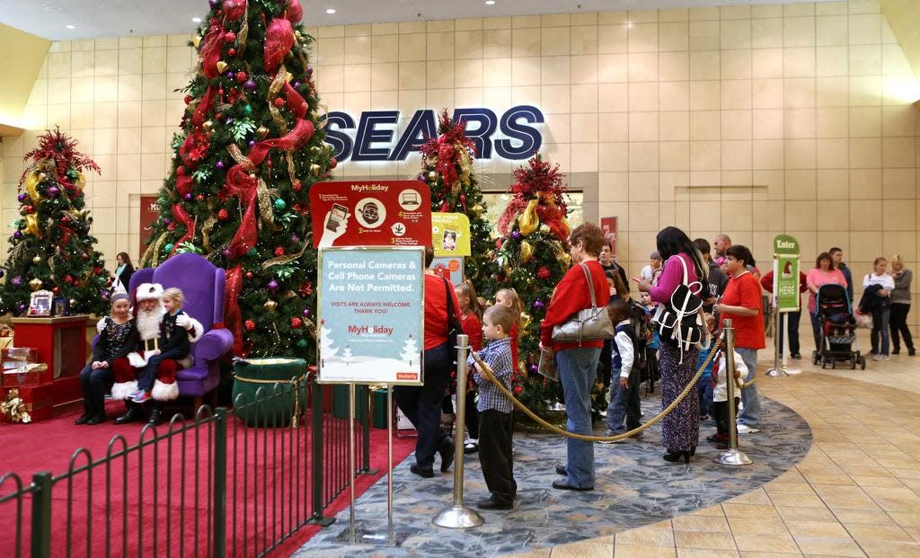 Mall-goers wait in line to get a photo with Santa Claus at Jefferson Mall the day before Christmas eve. Dec. 23, 2014.