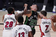 Boston Celtics' Daniel Theis (27) recoils from contact with Miami Heat's Andre Iguodala (28) during the second half of an NBA conference final playoff basketball game Friday, Sept. 25, 2020, in Lake Buena Vista, Fla. (AP Photo/Mark J. Terrill)