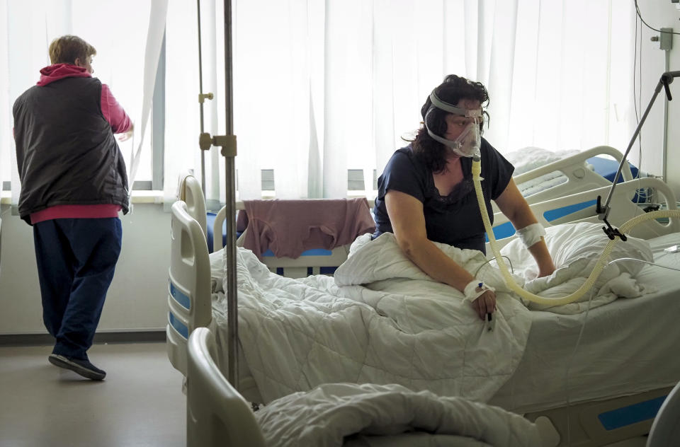 A nurse looks through a window as a coronavirus patient breathes oxygen, as she is not able to evacuate to a hospital basement during shelling by Azerbaijan's artillery in a hospital in Stepanakert, the separatist region of Nagorno-Karabakh, Wednesday, Oct. 28, 2020. Nagorno-Karabakh officials said Azerbaijani forces hit Stepanakert, the region's capital, and the nearby town of Shushi with the Smerch long-range multiple rocket systems, killing one civilian and wounding two more. (AP Photo)