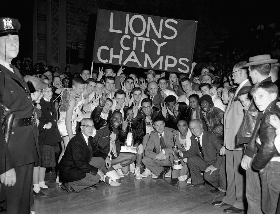 The Lanphier Lions and their fans gathered around the trophies they earned for winning the 1955 city high school basketball championship at the Illinois State Armory on Jan. 22. The jubilant moment began a stretch of four consecutive wins for the Lions and coach Arlyn Lober, who ranked second all-time with nine City Tournament championships.