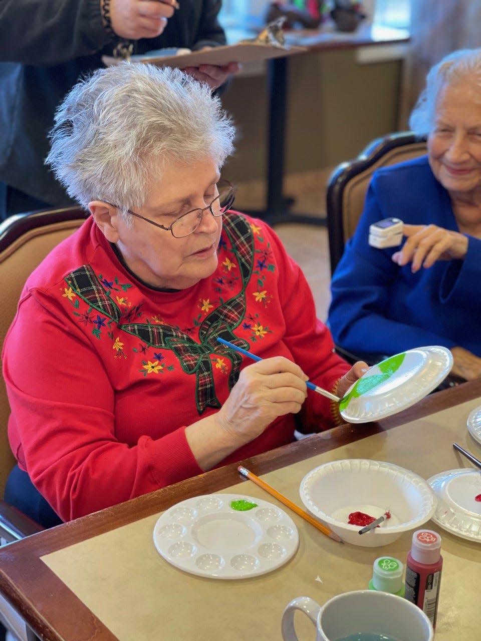 Cedarhurst of Springfield resident Stephanie Crownover paints a plate to look like a piece of candy. The gingerbread house she and other residents built and decorated won best overall in a company-wide contest.