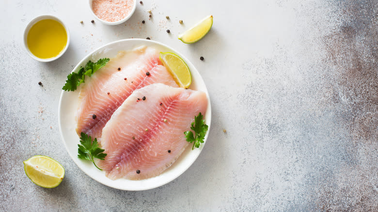raw tilapia fillets on plate