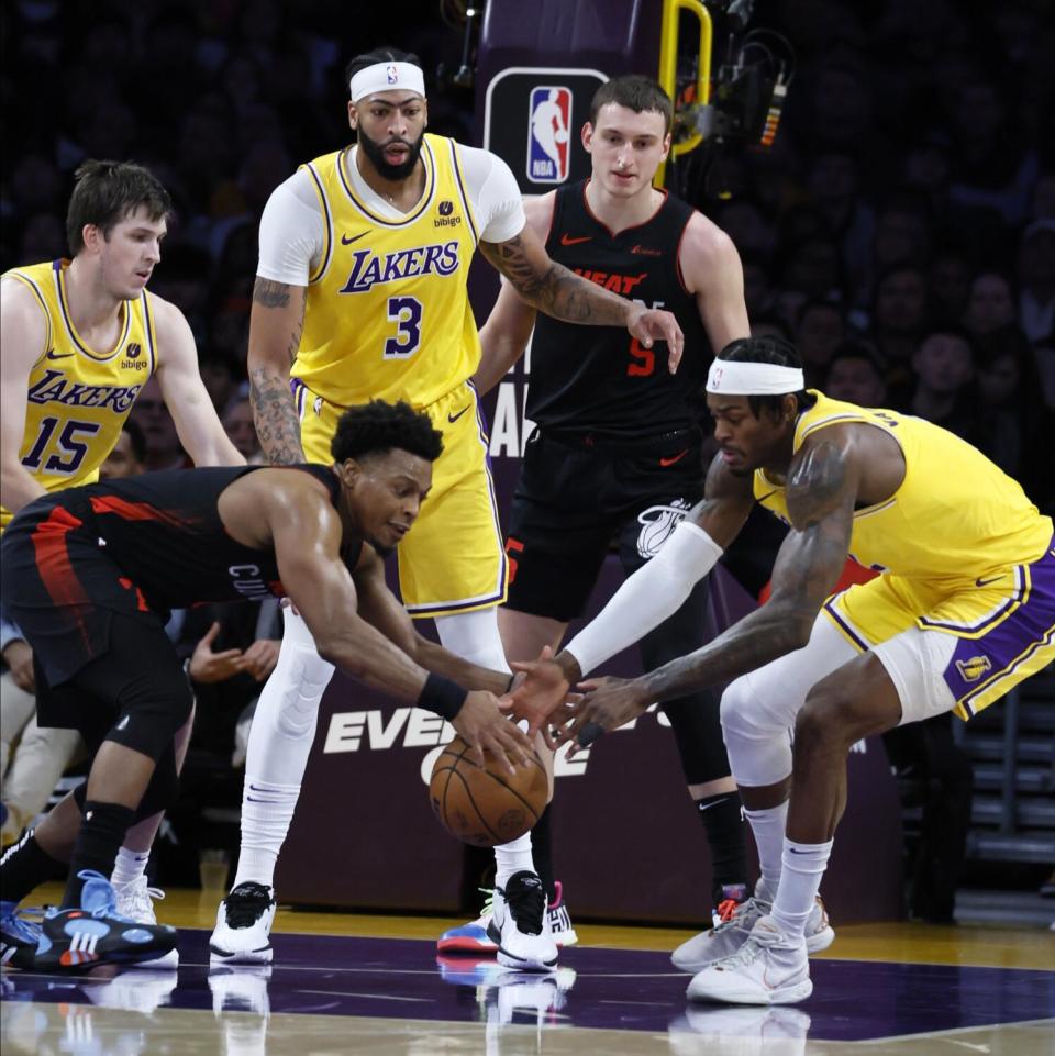 The Lakers' Jarred Vanderbilt and Heat's Kyle Lowry fight for a loose ball at Crypto.com Arena.