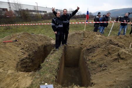 Winners, brothers Ladislav (L) and Csaba Skladan from Slovakia, pose for a photo during a grave digging championship in Trencin, Slovakia, November 10, 2016, where eleven pairs of gravediggers are competing in digging based on accuracy, speed, and aesthetic quality. REUTERS/Radovan Stoklasa