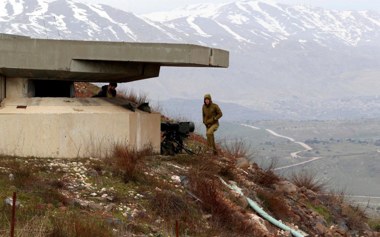 An Israeli soldier walks near a military post close to the Druze village of Majdal Shams in the Israeli-occupied Golan Heights on the Syrian border - REUTERS