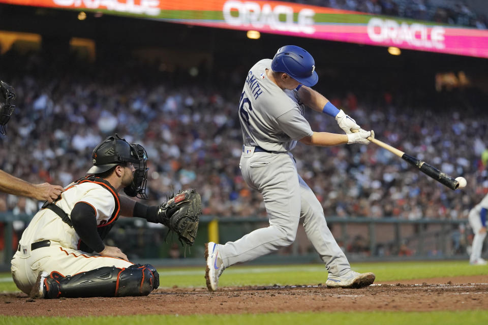 Los Angeles Dodgers' Will Smith, right, hits an RBI double in front of San Francisco Giants catcher Joey Bart during the fifth inning of a baseball game in San Francisco, Monday, Aug. 1, 2022. (AP Photo/Jeff Chiu)
