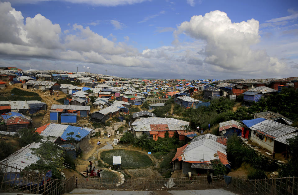 FILE - In this Aug. 26, 2018, file photo, Rohingya refugees bathe at a hand water pump at Kutupalong refugee camp in Bangladesh, where they have been living after feeing violence in Myanmar. A fire in a sprawling Rohingya refugee camp in Bangladesh Thursday, Jan. 14, 2021, has destroyed hundreds of homes. (AP Photo/Altaf Qadri, File)