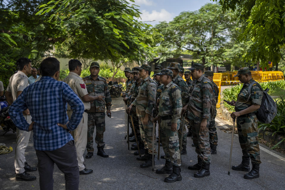 A Delhi police officer briefs a group of Indian paramilitary soldiers outside the Canadian High Commission in New Delhi, India, Tuesday, Sept. 19, 2023. Tensions between India and Canada are high after Prime Minister Justin Trudeau's government expelled a top Indian diplomat and accused India of having links to the assassination in Canada of Sikh leader Hardeep Singh Nijjar, a strong supporter of an independent Sikh homeland. (AP Photo/Altaf Qadri)