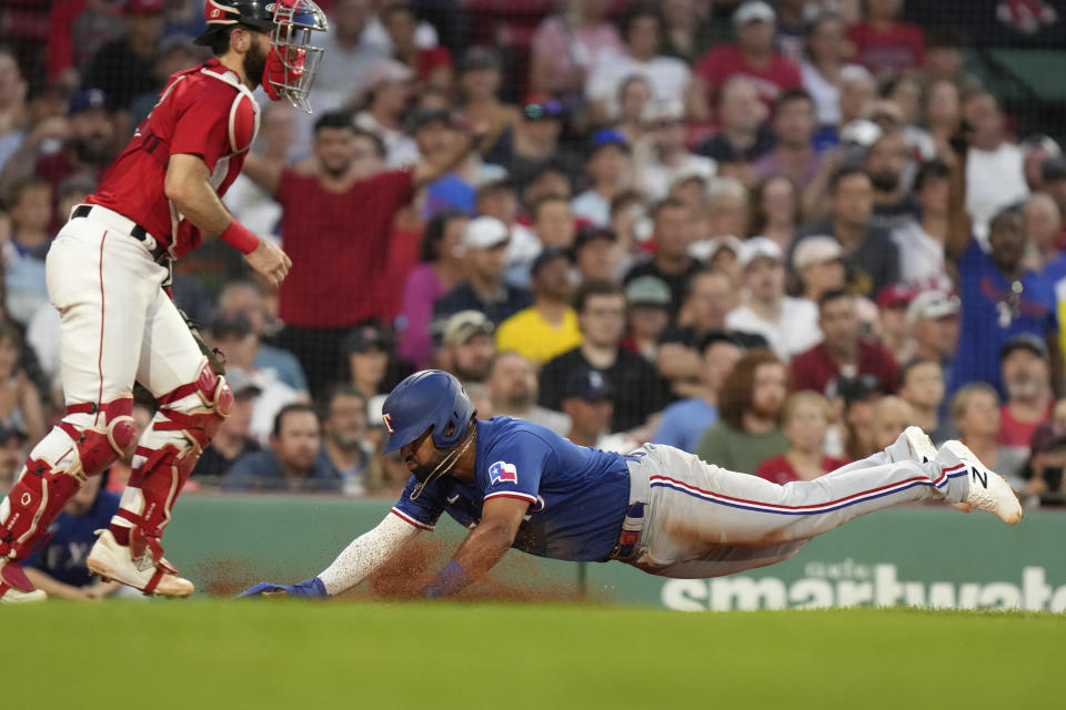 Texas Rangers' Ezequiel Duran scores on a single by Leody Taveras, next to Boston Red Sox's Connor Wong during the fourth inning of a baseball game Thursday, July 6, 2023, in Boston. (AP Photo/Steven Senne)