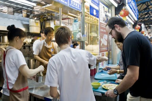 Tourists are seen here collecting their dishes at a stall in Maxwell Food Centre, a traditional Singaporean food centre near its financial district. Spurred by economic development and the opening of its two casino complexes, Singapore is beginning to compete with more established culinary capitals like Tokyo and Hong Kong with its western and fusion fare