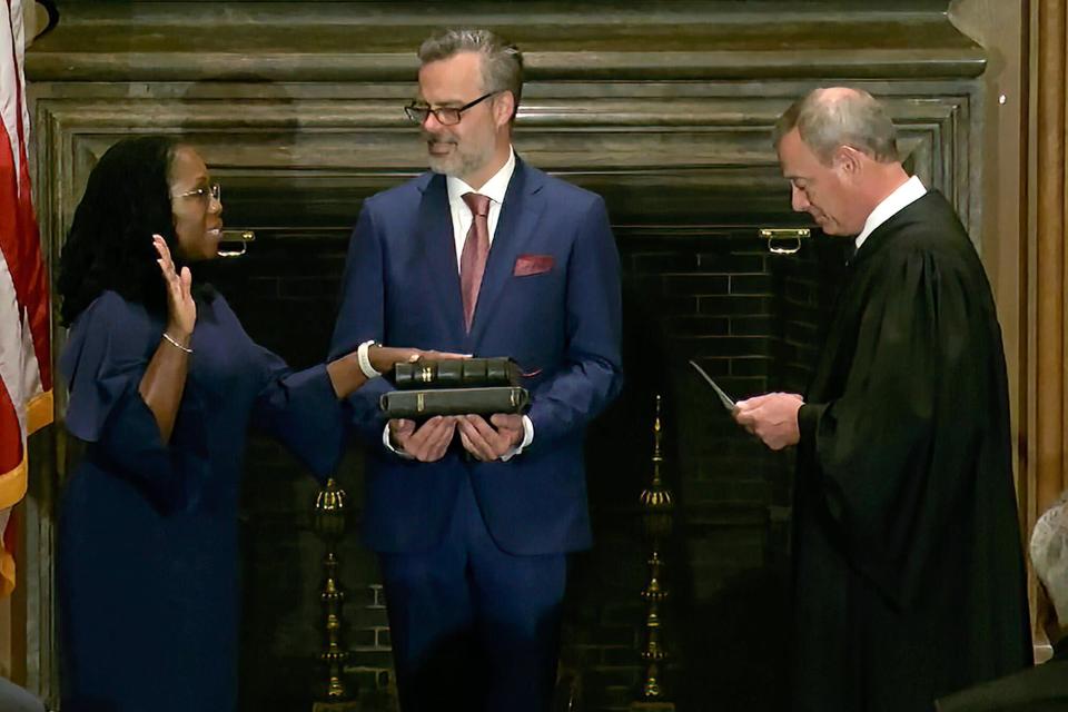 In this image from video provided by the Supreme Court, Chief Justice of the United States John Roberts administers the Constitutional Oath to Ketanji Brown Jackson as her husband Patrick Jackson holds the Bible at the Supreme Court in Washington, Thursday, June 30, 2022.
