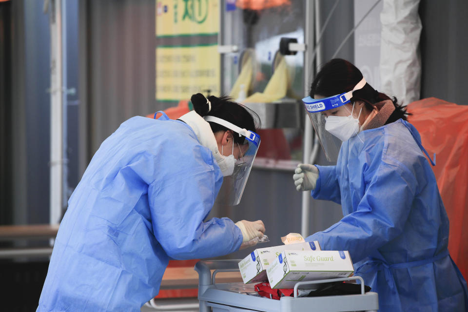 Medical workers wearing protective gear prepare for a coronavirus test at a coronavirus testing site in Seoul, South Korea, Sunday, Dec. 27, 2020. (Park Min-suk/Newsis via AP)