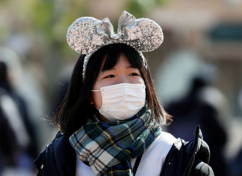 A visitor wearing protective face mask, following an outbreak of the coronavirus, is seen outside Tokyo Disneyland in Urayasu