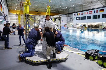 NASA Commercial Crew Astronaut Josh Cassada is helped to get into his space suit at NASA's Neutral Buoyancy Laboratory (NBL) training facility near the Johnson Space Center in Houston,