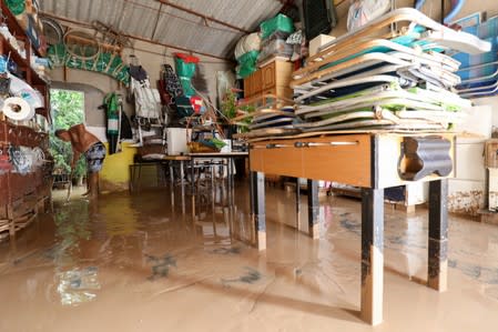 A man cleans his garage after heavy rains in Los Alcazeres