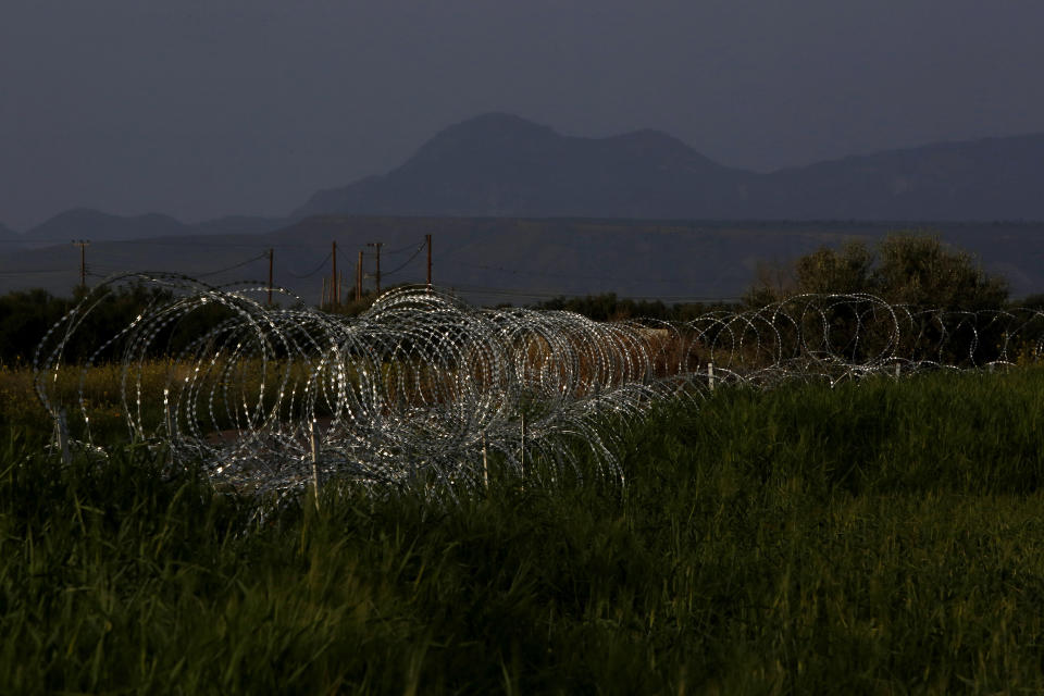 Razor wire is seen along the southern side of a U.N buffer zone that cuts across the ethnically divided Cyprus, near village of Astromeritis, Tuesday, March 9, 2021. The government of ethnically split Cyprus has come under fire over a decision to lay razor wire along a section of a U.N. controlled buffer zone it said is needed to stem migrant inflows from the island's breakaway north, with critics charging that the "ineffective" scheme only feeds partitionist perceptions amid a renewed push resume dormant peace talks. (AP Photo/Petros Karadjias)