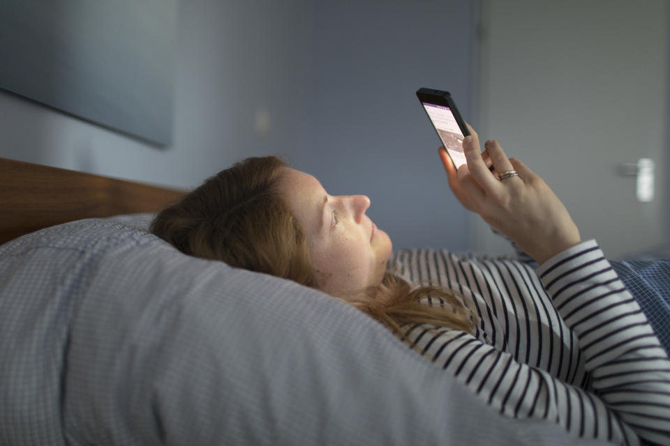 Bonn, Germany - February 13: Posed Scene: A young woman is lying in bed looking at her smartphone on February 13, 2018 in Bonn, Germany. (Photo Illustration by Ute Grabowsky/Photothek via Getty Images)