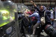 <p>Opositores al gobierno del presidente venezolano Nicolás Maduro se enfrentan a miembros de la Guardia Nacional Bolivariana de Venezuela durante una manifestación hoy, martes 4 de abril de 2017, que intentaba marchar hacia el Parlamento en apoyo a la destitución de los magistrados del Supremo, en Caracas (Venezuela). La Guardia Nacional Bolivariana de Venezuela (GNB, policía militar) disolvió hoy con gases lacrimógenos y perdigones de goma una manifestación de decenas de opositores. EFE/Manaure Quintero </p>