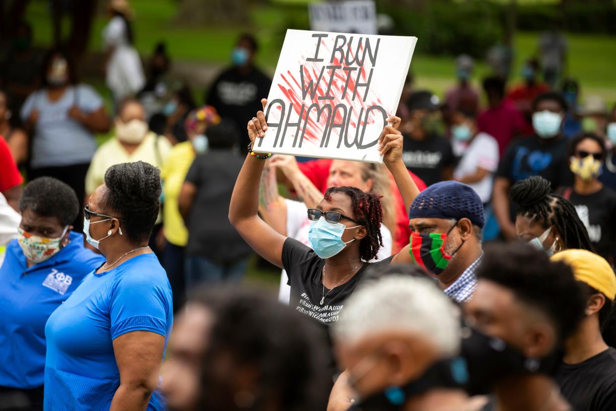 In this May 16, 2020, file photo, a woman holds a sign during a rally to protest the shooting of Ahmaud Arbery, in Brunswick, Ga. Arbery was shot and killed while running in a neighborhood outside the port city. Jury selection in the case is scheduled to begin Monday, Oct. 18.