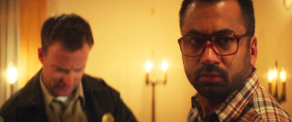 Kal Penn speaks with a police officer in "The Girl in the Photographs"