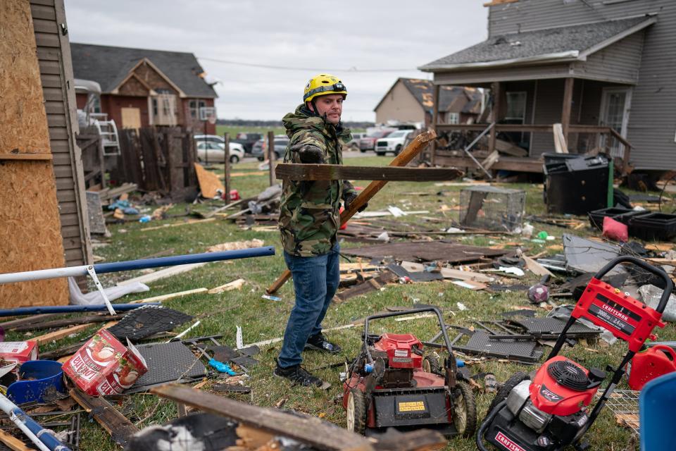 Dustin Arnold removes debris from his yard in Clarksville, Tenn., Sunday, Dec. 10, 2023. Tornadoes struck Middle Tennessee on Saturday, killing at least six people and leaving more than 160,000 Middle Tennessee residents without power.