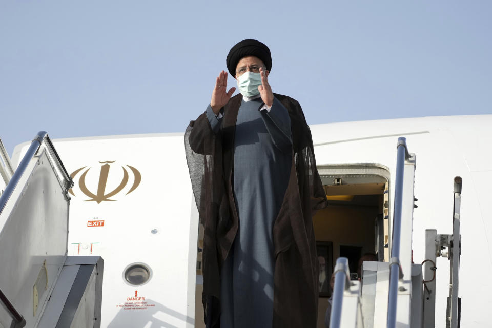 Iranian President Ebrahim Raisi waves to media and officials as he boards his plane departing Tehran's Mehrabad airport for a trip to Oman, Monday, May, 23, 2022. (AP Photo/Vahid Salemi)