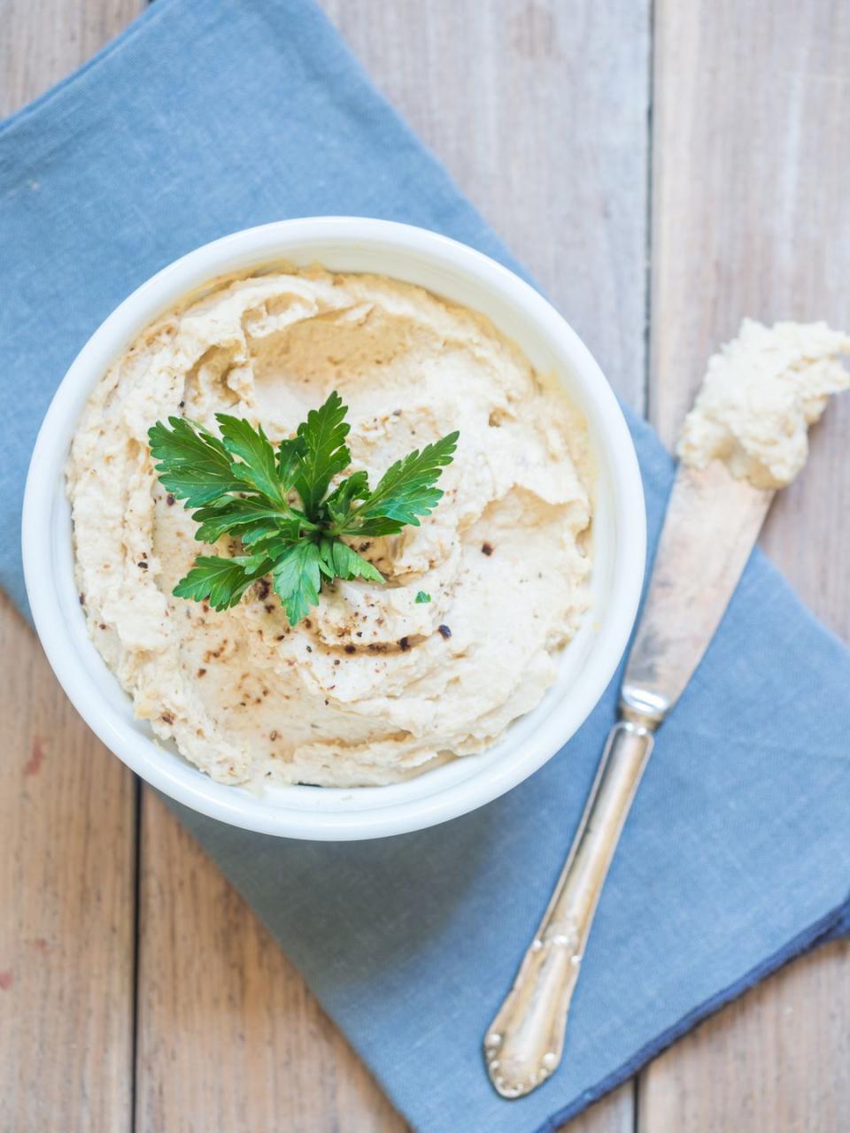 mediterranean diet meal plan hummus in a bowl topped with parsley with knife