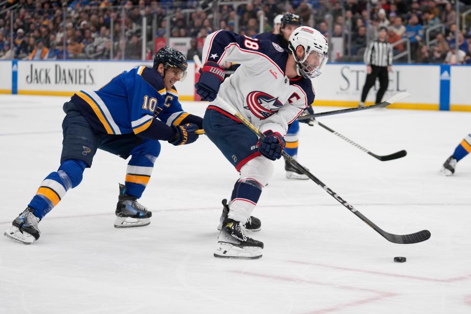 Columbus Blue Jackets' Boone Jenner, right, controls the puck as St. Louis Blues' Brayden Schenn (10) defends during the first period of an NHL hockey game Tuesday, Jan. 30, 2024, in St. Louis. (AP Photo/Jeff Roberson)