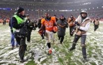 Denver Broncos running back C.J. Anderson (22) leaves the field following the overtime against the New England Patriots at Sports Authority Field at Mile High. The Broncos defeated the Patriots 30-24 in overtime. Mandatory Credit: Ron Chenoy-USA TODAY Sports