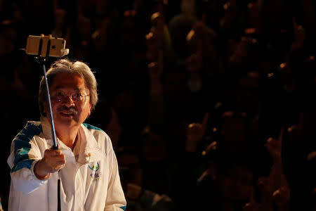 Candidate John Tsang, former Financial Secretary, takes a selfie during an election campaign at the financial Central district, two days before the Chief Executive election, in Hong Kong, China March 24, 2017. REUTERS/Bobby Yip