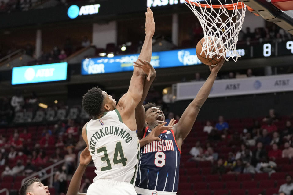 Houston Rockets forward Jae'Sean Tate (8) shoots as Milwaukee Bucks forward Giannis Antetokounmpo defends during the first half of an NBA basketball game Friday, Dec. 10, 2021, in Houston. (AP Photo/Eric Christian Smith)