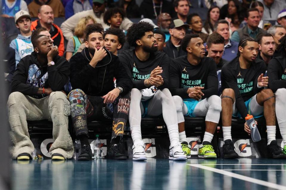 Hornets players Terry Rozier, far left, and Cody Martin, second from left, watch the game from the bench with injuries during the game against the Heat at Spectrum Center on Tuesday, November 14, 2023 in Charlotte, NC.