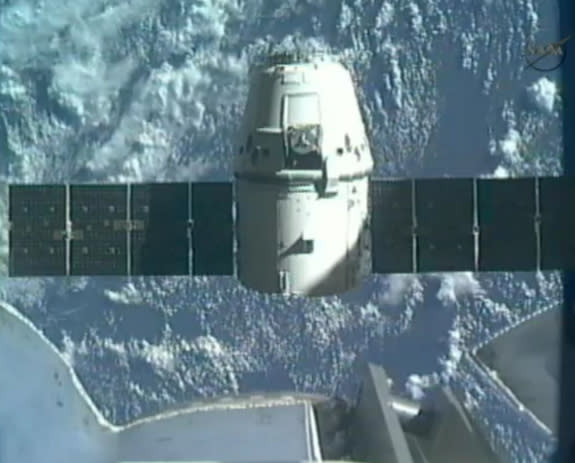 SpaceX's first Dragon space craft to the International Space Station backs away from the Canadarm2 robotic arm on the orbiting lab to begin the return trip to Earth on May 31, 2012, in this still from a NASA broadcast.