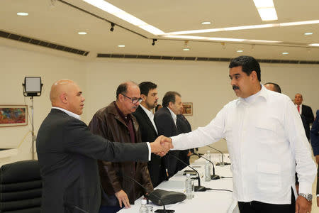 Venezuela's President Nicolas Maduro (R) shakes hands with Jesus Torrealba (L), secretary of Venezuela's coalition of opposition parties (MUD), during a political meeting between government and opposition, in Caracas, Venezuela October 30, 2016. Miraflores Palace/Handout via REUTERS