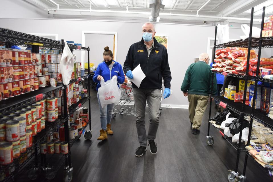 Gov. Phil Murphy and CUMAC volunteer coordinator Jeni Mastrangelo shop for clients Monday. Murphy and New Jersey first lady Tammy Murphy visited CUMAC, a food pantry, in Paterson, N.J., and bagged food after touring the facility on Martin Luther King Jr. Day.
