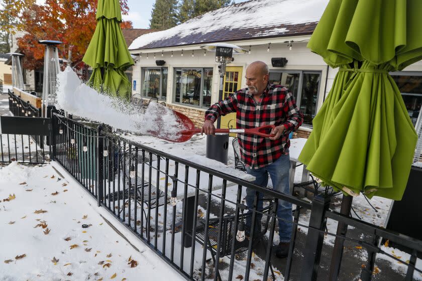 Big Bear, CA, Thursday, Nov. 3, 2022 - Maintenance manager Rick Walker clears snow from the patio at Pergola Trattoria, downtown. (Robert Gauthier/Los Angeles Times)
