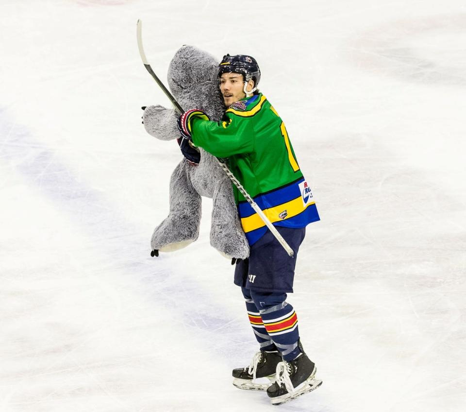 Rivermen defenseman Zach Wilkie joins in the Teddy Bear Toss cleanup, hugging a huge bear during Peoria's 5-3 win over Huntsville at Carver Arena on Saturday, Dec. 10, 2022.