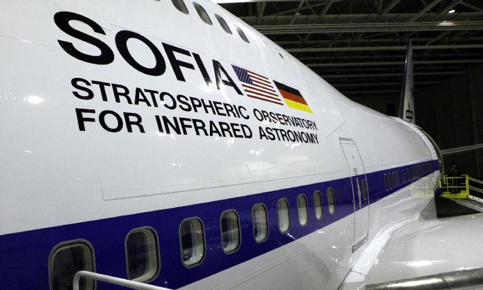FILE - In this April 20, 2010, file photo, U.S. and German flags are seen on the side of the aircraft at the first public viewing of the Stratospheric Observatory for Infrared Astronomy (SOFIA), a cooperative venture between NASA and German scientists, where a 2.8-meter (98-inch) telescope has been mounted inside specially modified Boeing 747-SP, at the NASA Dryden Flight Research Center test facility in Palmdale, Calif. The White House released its budget on Tuesday, March 4, 2014, that proposes to mothball the observatory unless Germany and other partners can kick in more money. (AP Photo/Reed Saxon, File)