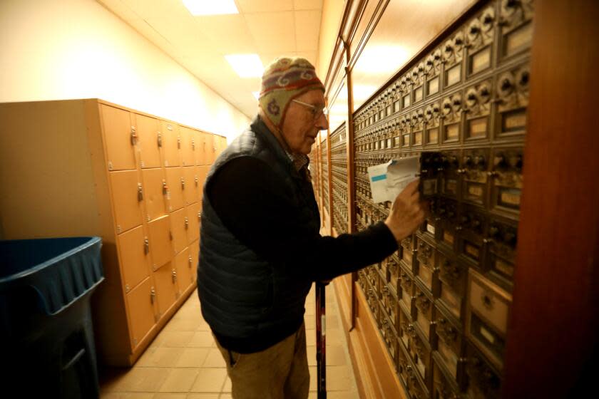 CARMEL-BY-THE-SEA, CA - JANUARY 12, 2024 - - Hans Lehmann, 91, collects his mail from his post office box at the post office in downtown Carmel-By-The-Sea on January 12, 2024. Because there are no street addresses in the city, Lehmann, who has lived in Carmel since 1939, has to pick up his mail from his post office box. He finds the post office a good place to meet friends, enjoy a conversation and embrace the strong sense of community on his daily trips. Carmel-By-The-Sea has never had street addresses - except the post office - and does not have at-home postal delivery. The town is now debating about getting addresses because it's hard to get packages, and Medicare coverage, when you don't have a physical address. More places don't accept PO Boxes. (Genaro Molina/Los Angeles Times)