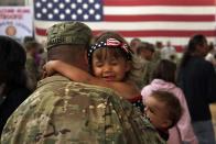 <p>Reniah Krause, 2, clings to her father Sgt. Joseph Krause after he and fellow soldiers return home from Afghanistan. More than 500 soldiers from the 1st Brigade Combat Team came back that day following a year of heavy fighting and numerous casualties in Afghanistan's southern Kandahar province. </p>