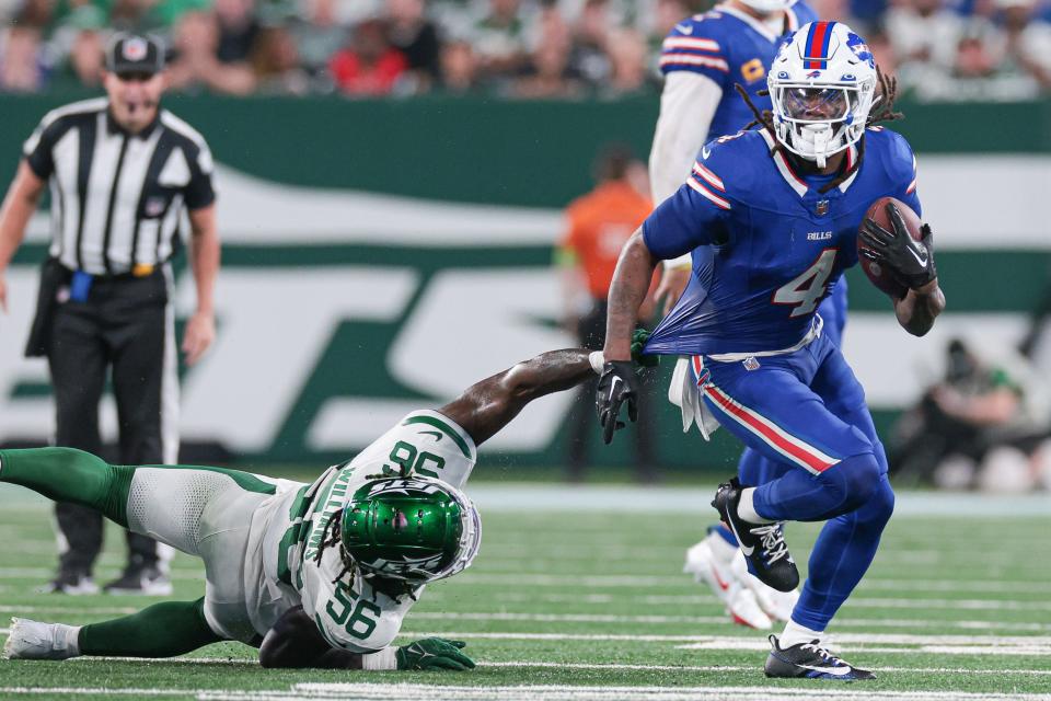 Sep 11, 2023; East Rutherford, New Jersey, USA; Buffalo Bills running back James Cook (4) rushes the ball against New York Jets linebacker Quincy Williams (56) during the first half at MetLife Stadium. Mandatory Credit: Vincent Carchietta-USA TODAY Sports