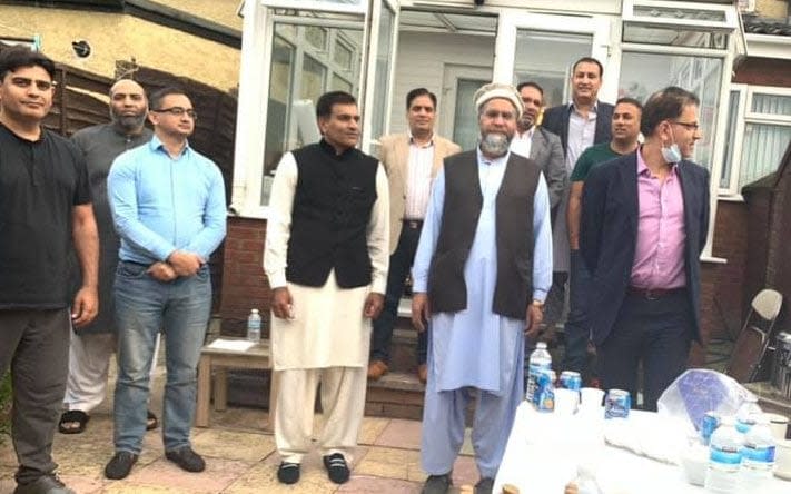 Cllr Malik, in the pink shirt and wearing glasses, at the garden party - Social Media Internet/Social Media Internet