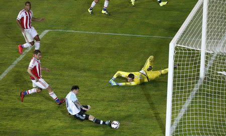 Argentina's Lionel Messi (bottom) misses a goal opportunity against Paraguay during their first round Copa America 2015 soccer match at Estadio La Portada de La Serena in La Serena, Chile, June 13, 2015. REUTERS/David Mercado