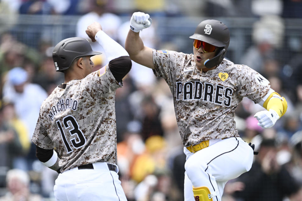 San Diego Padres' Ha-Seong Ki,m right, is congratulated by Manny Machado (13) after he hit a three-run home run during the second inning of the team's baseball game against the San Francisco Giants, Sunday, March 31, 2024, in San Diego. (AP Photo/Denis Poroy)