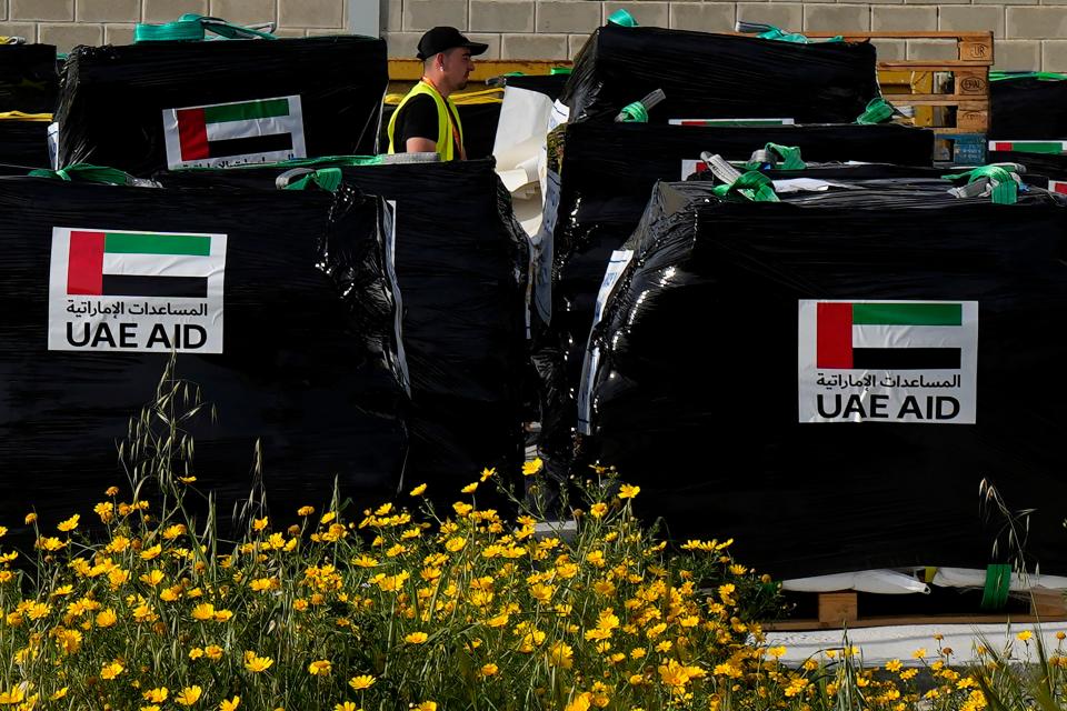 A member of the World Central Kitchen walks by humanitarian aid being loaded for transport to the port of Larnaca, Cyprus, for shipment to Gaza on March 13, 2024.