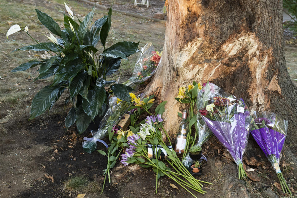 Flowers and gifts are laid at the site of a deadly car crash during an impromptu memorial service on Sunday, Oct. 2, 2022, in Lincoln, Neb. (Kenneth Ferriera/Lincoln Journal Star via AP)