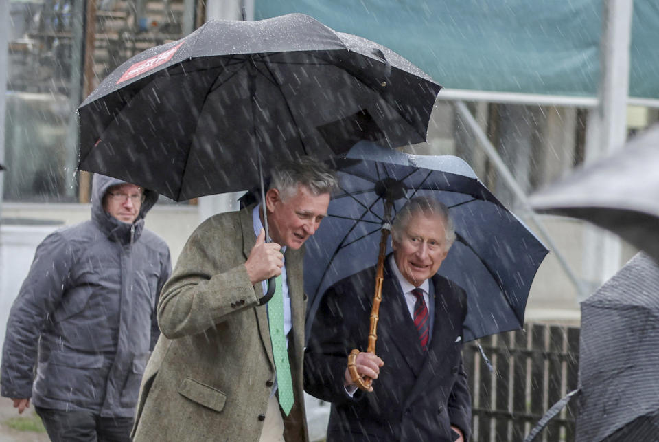 FILE - King Charles III of Great Britain, right, leaves the Brodowin ecovillage in the rain, Germany, Thursday, March 30, 2023. King Charles III won plenty of hearts during his three-day visit to Germany, his first foreign trip since becoming king following the death of his mother, Elizabeth II, last year. (Jens Buettner/DPA via AP, Pool, File)