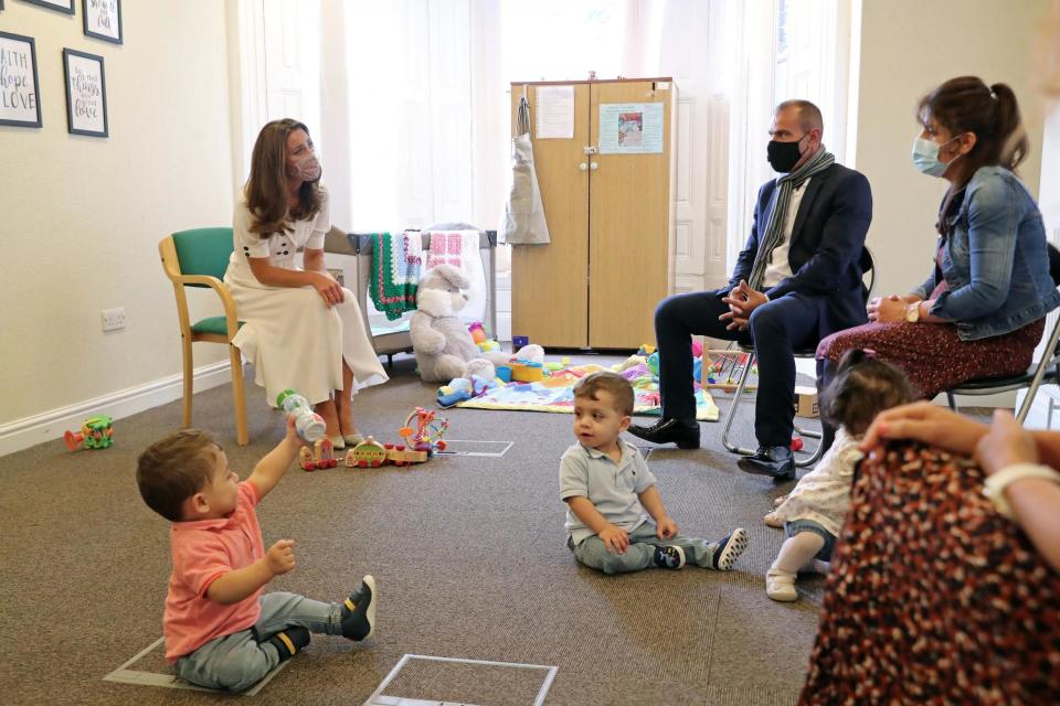 Kate talks to a family supported by Baby Basics (PA)