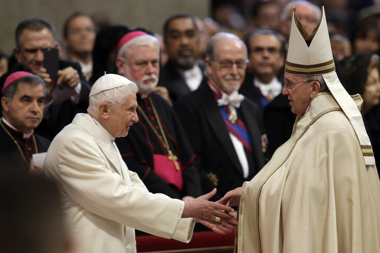 FILE - Pope Emeritus Benedict XVI, left, greets Pope Francis in St. Peter's Basilica at the Vatican, Saturday, Feb. 14, 2015. Pope Francis has said that if and when he ever retires, he wouldn’t live in the Vatican or return to his native Argentina but would like to find a church in Rome where he could continue hearing confessions. “I’m the bishop of Rome, in this case the emeritus Bishop of Rome,” Francis said in an interview broadcast Tuesday, July 12, 2022 with Spanish-language broadcaster Univision. (AP Photo/Andrew Medichini, File)