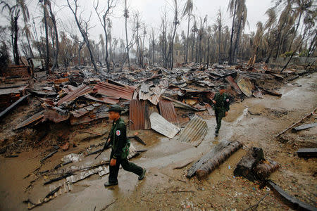 FILE PHOTO: Soldiers patrol through a neighbourhood that was burnt during recent violence in Sittwe June 14, 2012. To match Special Report MYANMAR-FACEBOOK/HATE REUTERS/Soe Zeya Tun/File Photo